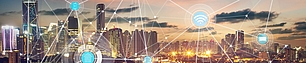 Illuminated city skyline with overlaid wireless and spectrum connectivity symbols representing modern spectrum regulation.