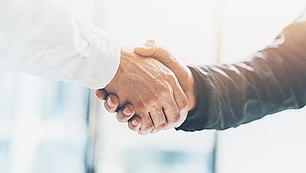 Handshake between two business people representing international coordination in frequency planning and ITU processes